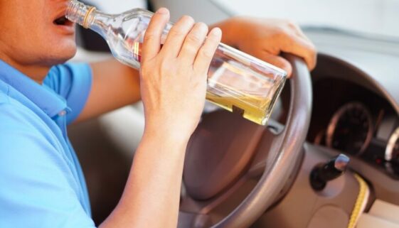 Close,Up,Man,Holds,Bottle,Of,Whiskey,To,Drink,In Was sind die rechtlichen Konsequenzen einer fahrlässigen Trunkenheit im Verkehr gemäß § 316 StGB?