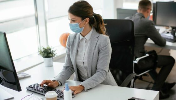 Beautiful,Businesswoman,With,Medical,Mask,Working,In,Office.,Covid-19,Concept. Pandemie-Maskenpflicht: Arbeitsplatz-Verstoß