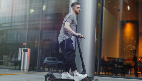 Attractive,Man,Riding,A,Kick,Scooter,At,Cityscape,Background. Trunkenheitsfahrt mit e-scooter