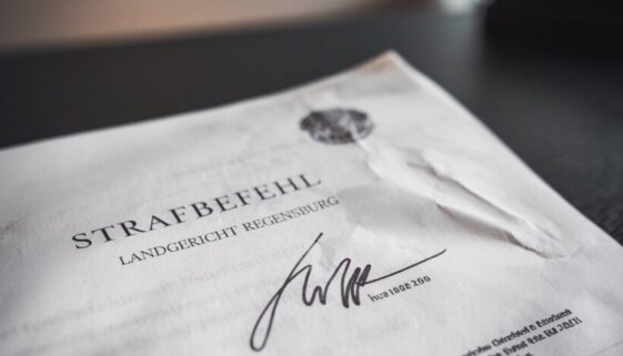 unterschriftserfordernis-strafbefehl-urteil Deutscher Strafbefehl mit unscharfer Unterschrift des Richters und sichtbarem Nachnamen-Stempel.