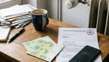 Unberührte 100-Euro-Scheine liegen neben einem offiziellen Brief der Seenotretter auf einem verstaubten Schreibtisch.